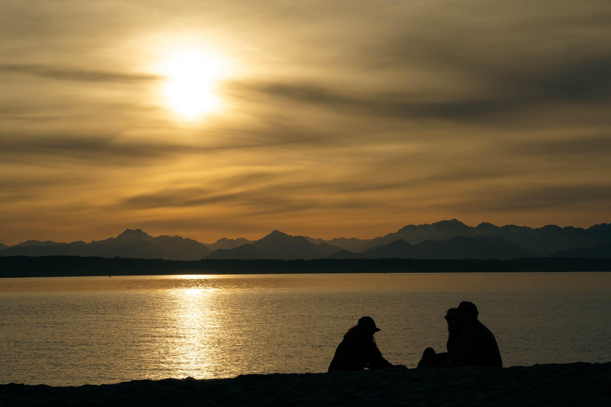 Silhouettes at sunset by water